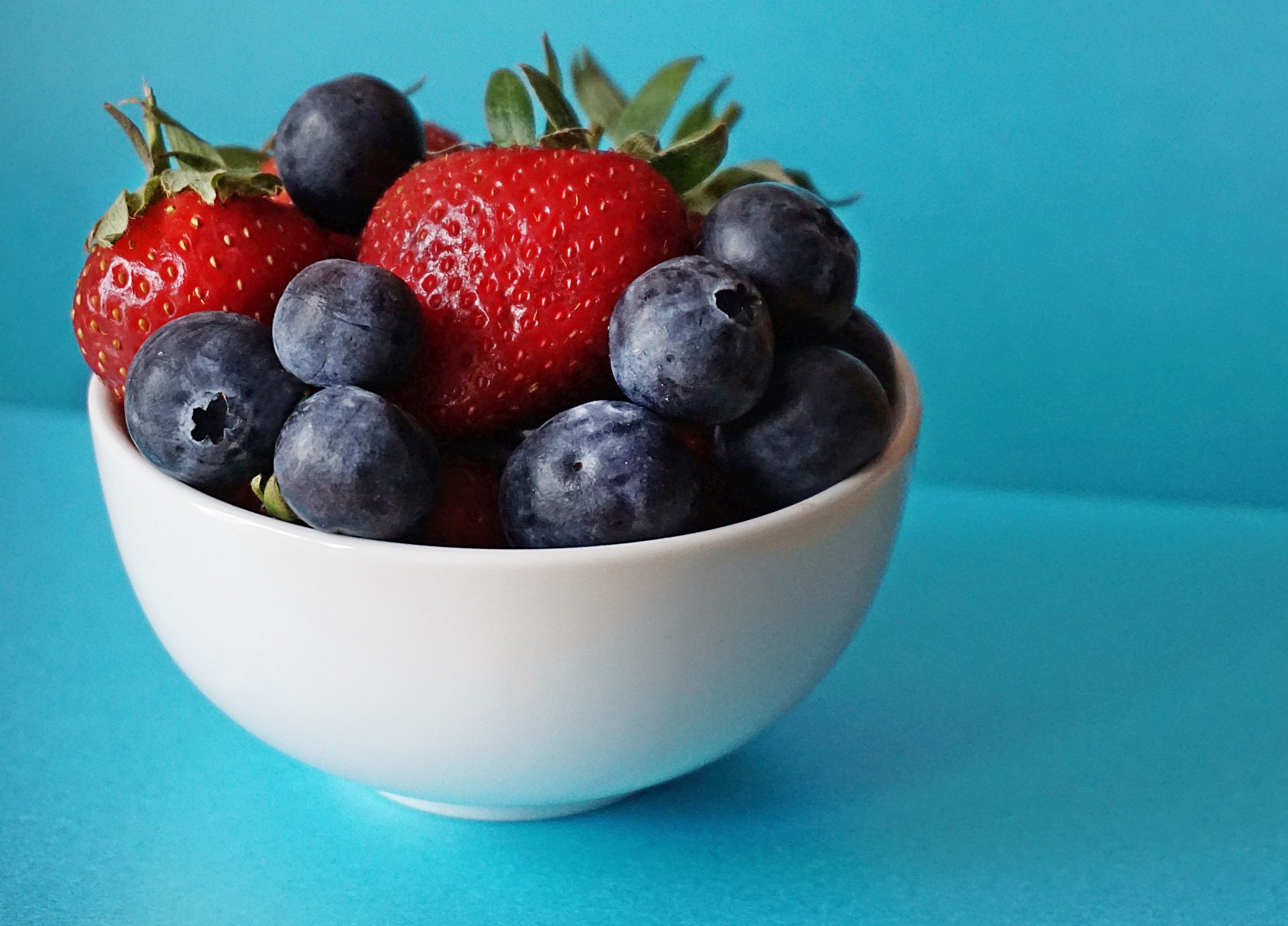 blueberries and strawberries in white ceramic bowl 1120575 scaled